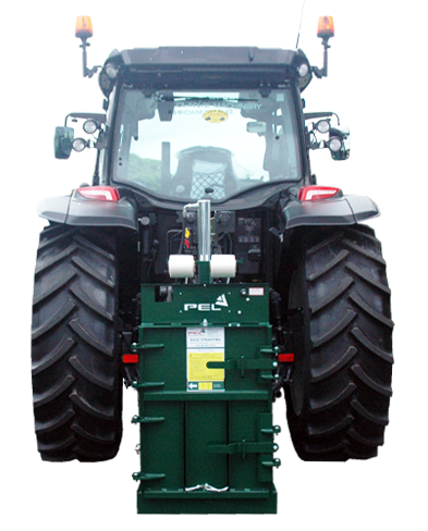 Agricultural baler for plastic and cardboard on back of tractor for making bales bale