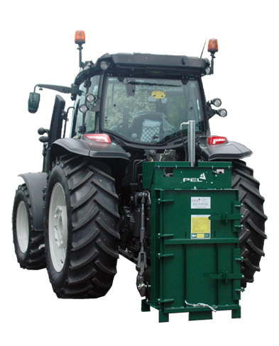 Agricultural baler on back of tractor for making bales bale